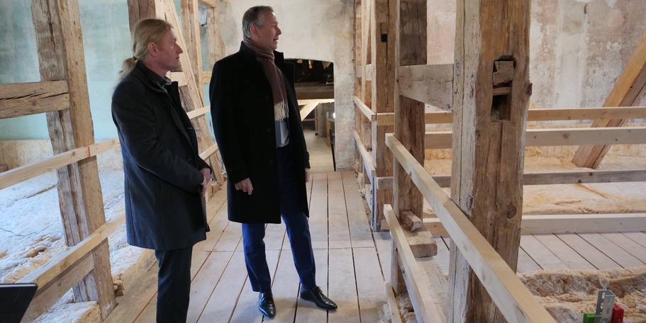 Herr Greier zeigt Finanzminister Dr. Geue den neu geschaffenen Rettungsweg im Dachgeschoss der Orangerie. © 2023 SBL Neubrandenburg