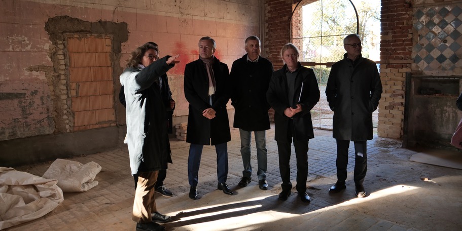 Frau John erläutert die Bauarbeiten in der ehemaligen Stallung des Südflügels im Marstall. © 2023 SBL Neubrandenburg