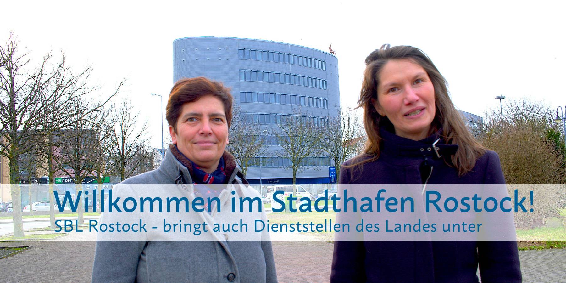Carmen-Alina Botezatu (re.) leitet das SBL Rostock und ist mit Sandra Auris (li.), Sachbearbeiterin Liegenschaftsmanagement im SBL Rostock, für die Unterbringung der aDiLaS verantwortlich. Im Hintergrund: Gebäude am Stadthafen in Rostock – dort ist u. a. © 2024 Christian Hoffmann (sbl-mv / Finanzministerium MV)