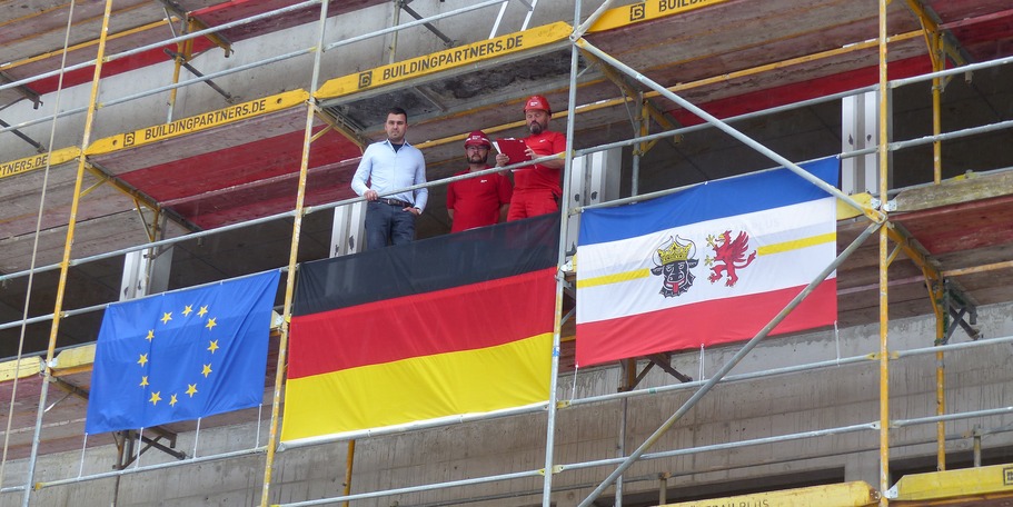 Polier Andi Möller von der Firma Riedel Bauunternehmen und Co.KG, Niederlassung Erfurt verliest den Richtspruch; links im Bild der zuständige Leiter Dezernat Bauhütte Universitätsmedizin im SBL Greifswald Enrico Richter © 2024 SBL Greifswald