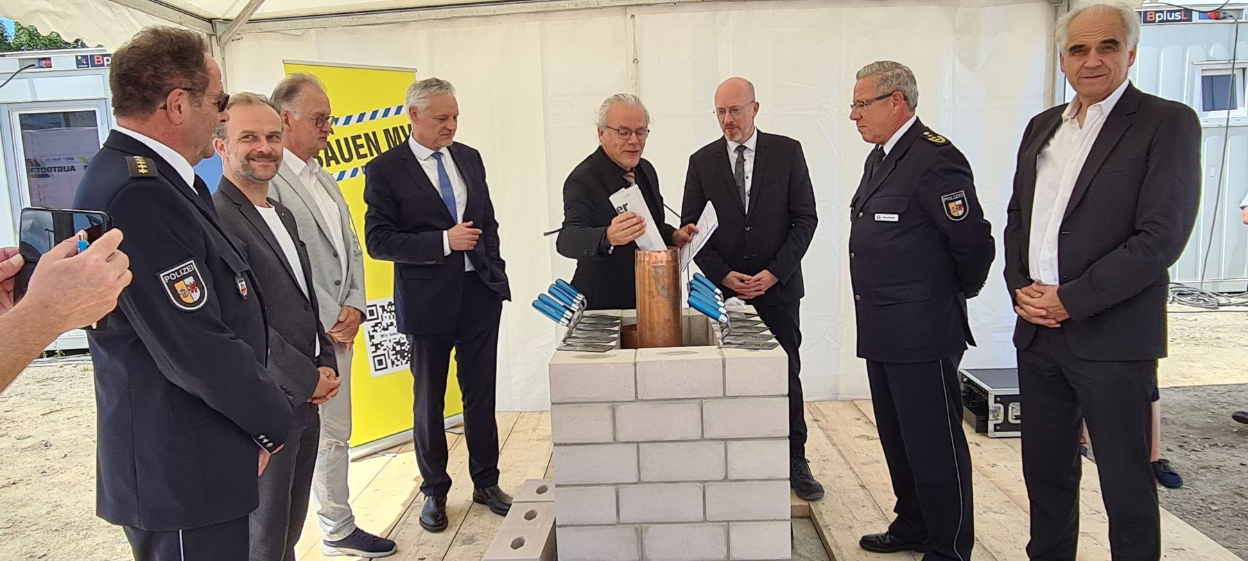 Befüllen der Zeitkapsel: Gunnar Mächler, Leiter Führungsstab im Polizeipräsidium Neubrandenburg, Neubrandenburgs OB Witt, Landrat Kärger, Stefan Wenzl, Jens Rott, Minister Pegel, Inspekteur der Polizei in Mecklenburg-Vorpommern Hoffmann-Ritterbusch u. Arc © 2024 Staatliches Bau- und Liegenschaftsamt Neubrandenburg