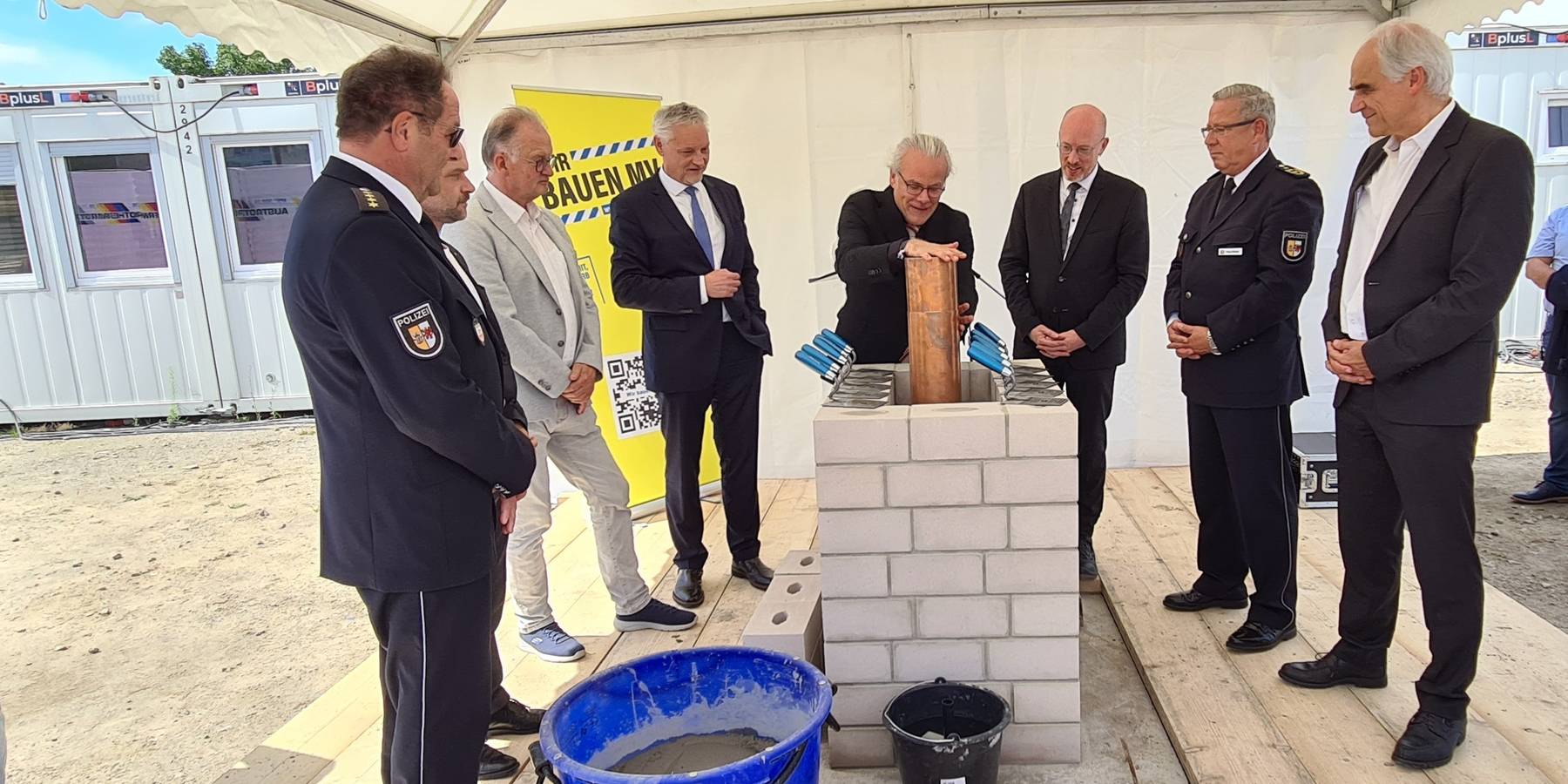 Versenken der Zeitkapsel: Gunnar Mächler, Leiter Führungsstab im Polizeipräsidium Neubrandenburg, Neubrandenburgs OB Witt, Landrat Kärger, Stefan Wenzl, Jens Rott, Minister Pegel, Inspekteur der Polizei in Mecklenburg-Vorpommern Hoffmann-Ritterbusch u. Ar © 2024 Staatliches Bau- und Liegenschaftsamt Neubrandenburg