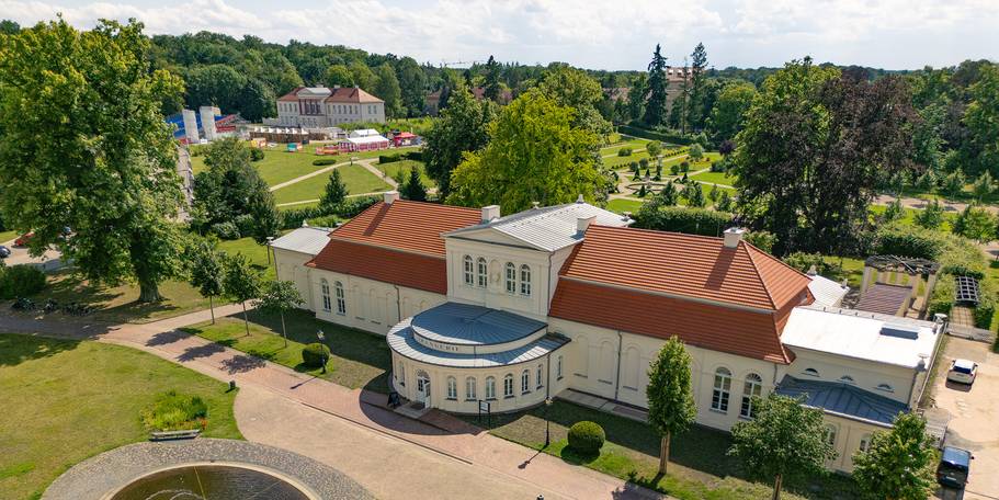Blick auf den Vorplatz, die östliche Fassade und das Dach der Orangerie im Vordergrund sowie den Schlossgarten und das Kavalierhaus im Hintergrund. © 2024 Christian Hoffmann (sbl-mv / Finanzministerium MV)