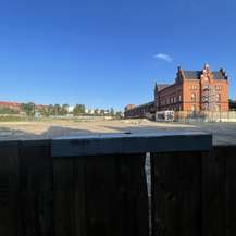 Blick über den Bauzaun auf das Baufeld © 2024 Ulrike Pannier SBL Rostock