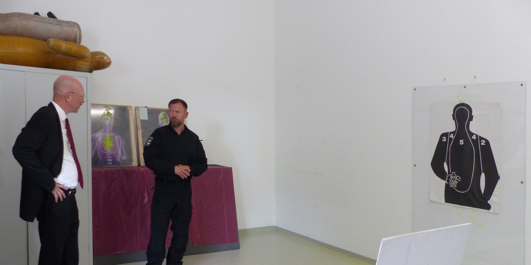 Während des Besichtigungsrundganges im Raum für Schießtraining, v.l.n.r.: Innenminister Christian Pegel und Polizeioberkommissar und Einsatztrainer ETR Nico Kubsch © 2024 SBL Greifswald