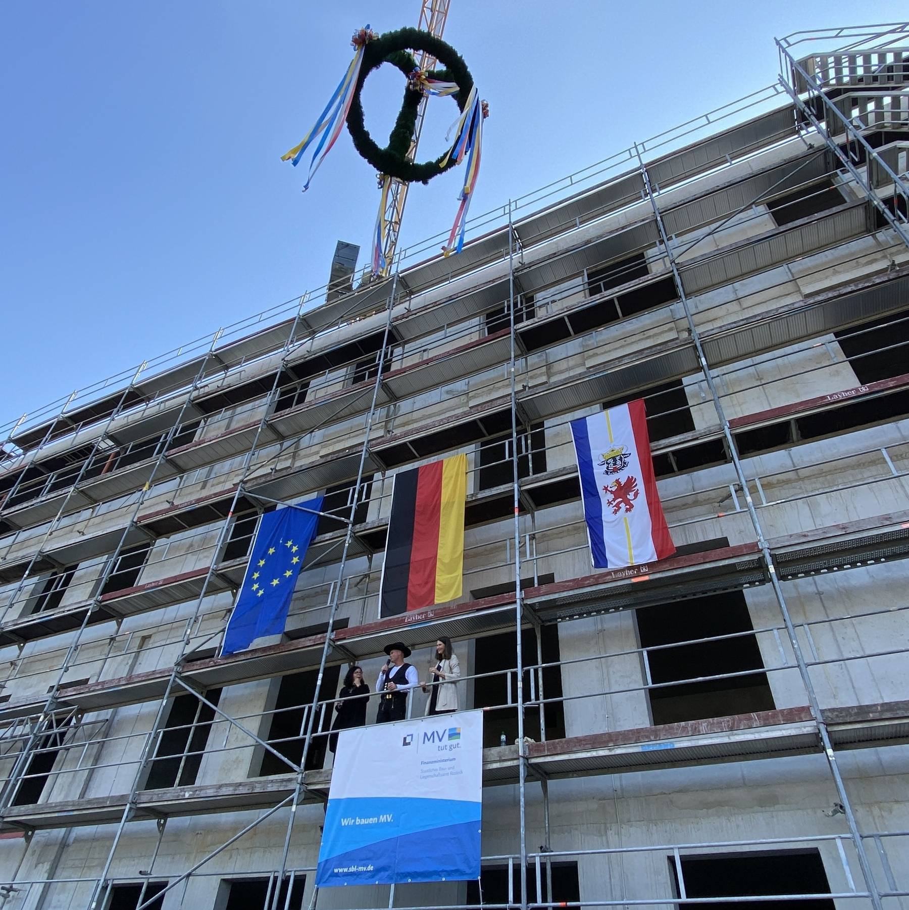Richtspruch auf dem Gerüst v.l. Projektleiterin Frau Wehrle, Polier, Leiterin des SBL Rostock Carmen-Alina Botezatu © 2024 Monika Mück (Finanzministerium MV)