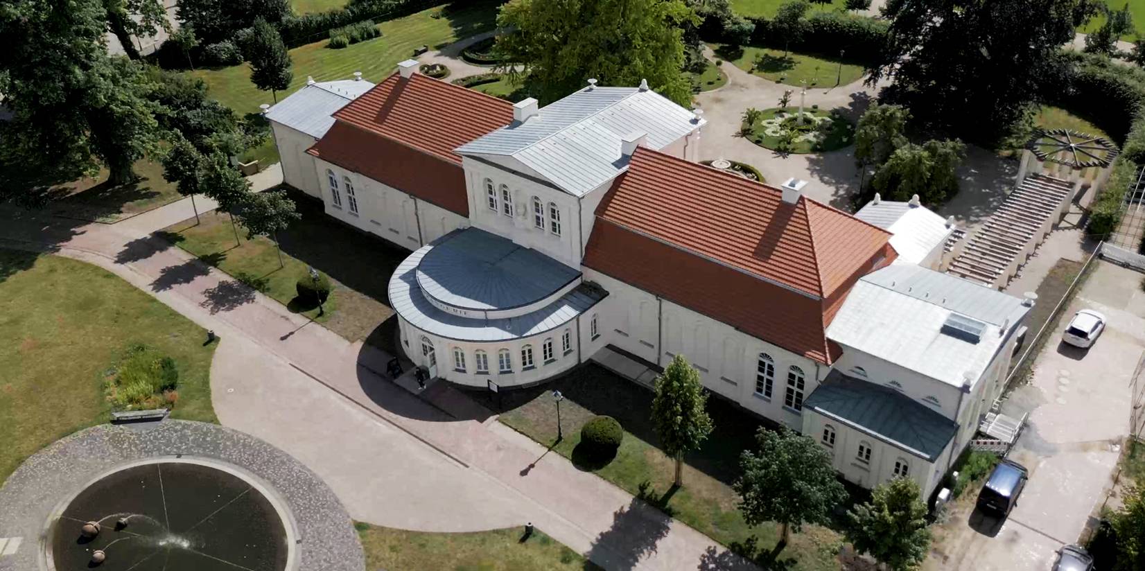 Blick auf die östliche Fassade der Orangerie mit Vorplatz, im Hintergrund der Garten mit dem Laubengang © 2024 Christian Hoffmann (sbl-mv / FM)