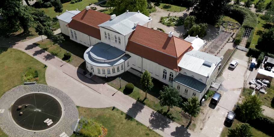 Blick auf die östliche Fassade der Orangerie mit Vorplatz, im Hintergrund der Garten mit dem Laubengang © 2024 Christian Hoffmann (sbl-mv / FM)