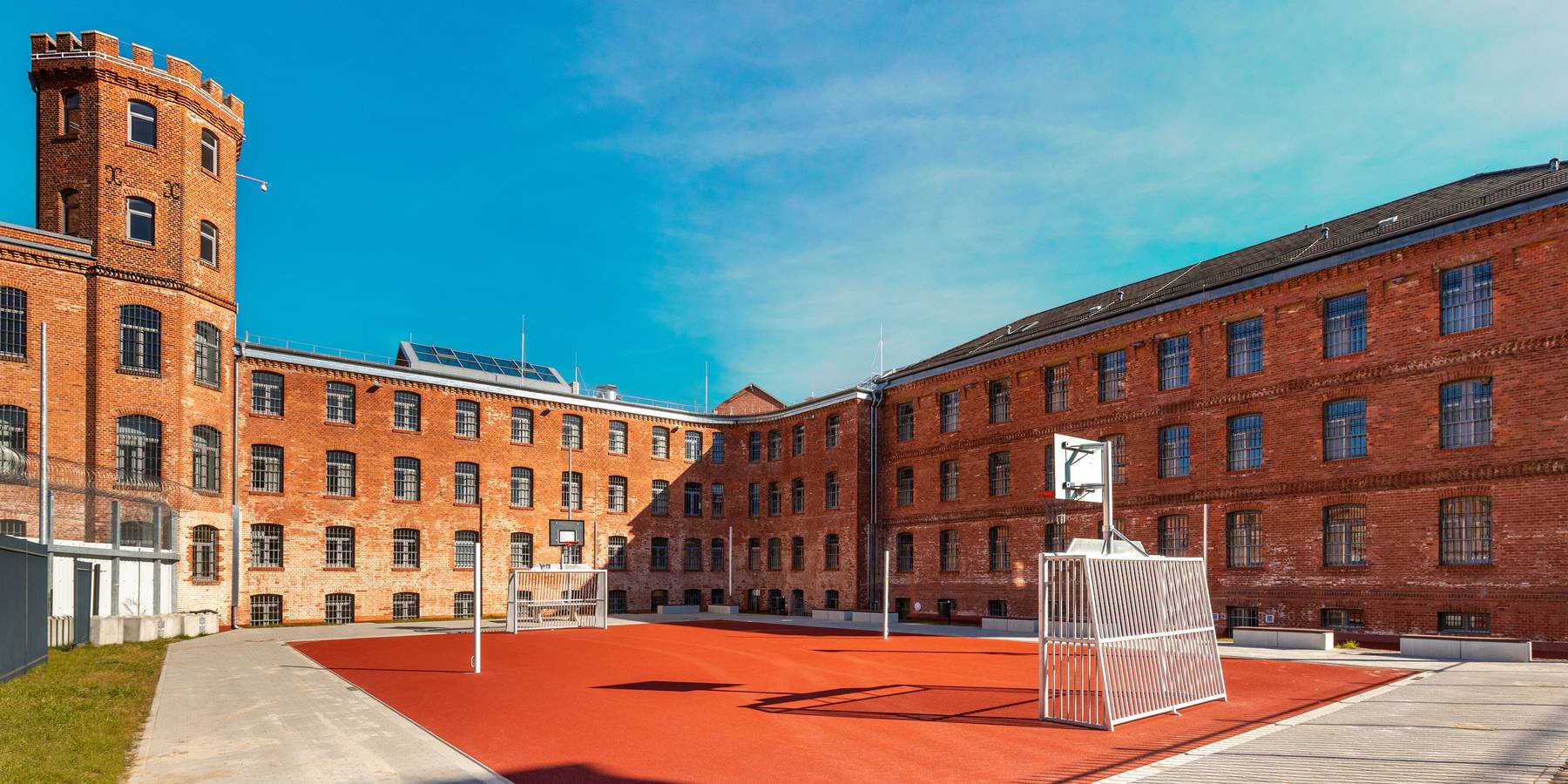 Das sanierte Hafthaus B mit dem Frauenvollzug und mit dem Transportzellenbereich im rechten Gebäudeteil, im Vordergrund der Freizeithof mit Kleinspielfeld. © 2025 Christoph Meyer/Paperheroes