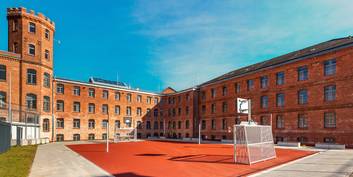 Das sanierte Hafthaus B mit dem Frauenvollzug und mit dem Transportzellenbereich im rechten Gebäudeteil, im Vordergrund der Freizeithof mit Kleinspielfeld. © 2025 Christoph Meyer/Paperheroes