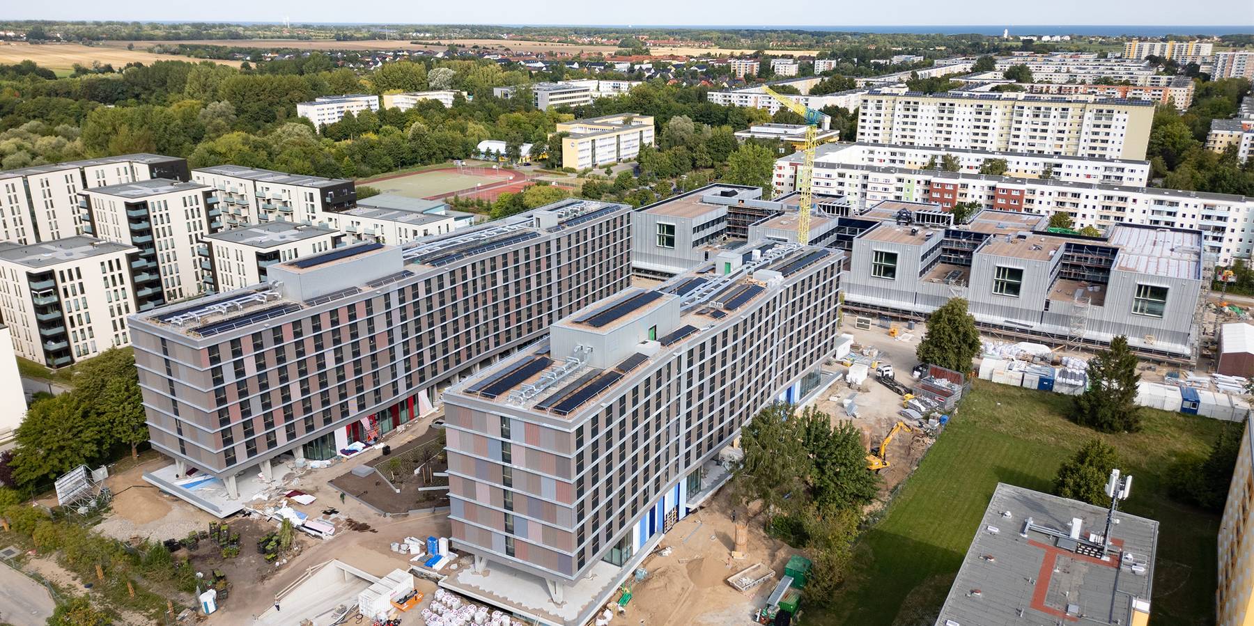 Blick aus Südwest auf die Wohngebäude mit der besonderen Fassade aus Holz © 2025 SBL-MV (Ministerium für Finanzen und Digitalisierung Mecklenburg-Vorpommern)