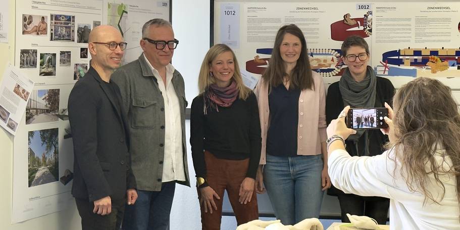 Wettbewerbsausstellung – Ingo Vetter ´Hände gleichen Werts´ und Ellen Möckel ´Zonenwechsel´ stellten ihre Entwürfe interessierten Besuchern vor (von links: Herr Herold, Herr Vetter, Frau Möckel, Frau Botezatu, Frau Müllner). © 2025 Christian Hoffmann (SBL-MV / Ministerium für Finanzen und Digitalisierung MV)