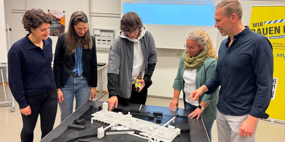 Im Dialog! von links: Ilana Zorbas und Carmen-Alina Botezatu vom SBL Rostock, Ben Passow vor seinem Modell, Janine Chlebek von der SBL-MV und Steffen Güll vom Bund Deutscher Baumeister. © 2025 Christian Hoffmann (SBL-MV / Ministerium für Finanzen und Digitalisierung MV)