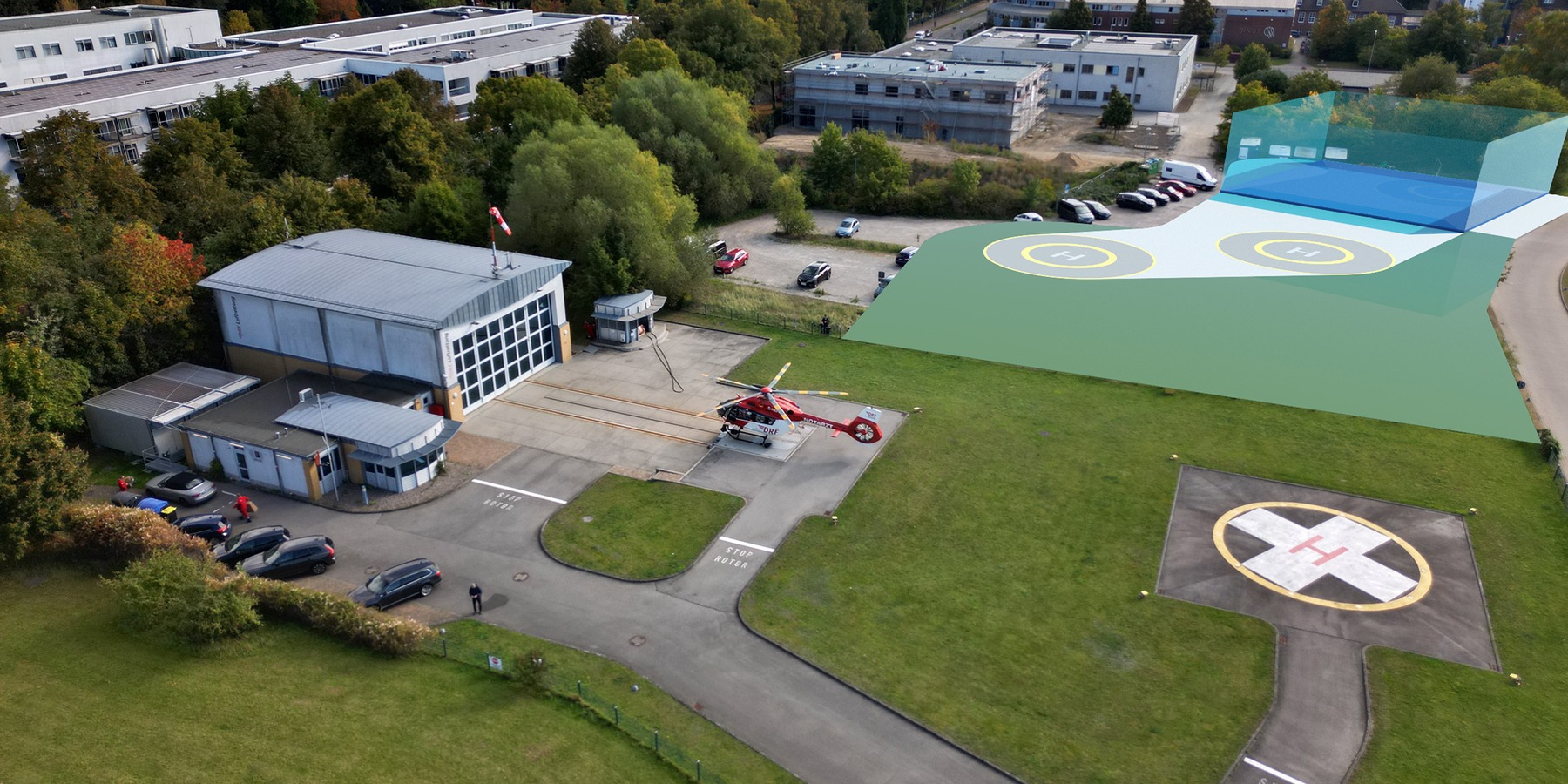 Luftbild vom Standort der DRF Luftrettungsstation Greifswald mit Visualisierung des geplanten Neubaus, der auf dem angrenzenden Parkplatz entstehen soll © 2025 Christian Hoffmann (SBL-MV / Ministerium für Finanzen und Digitalisierung Mecklenburg-Vorpommern) / Andreas Freiheit