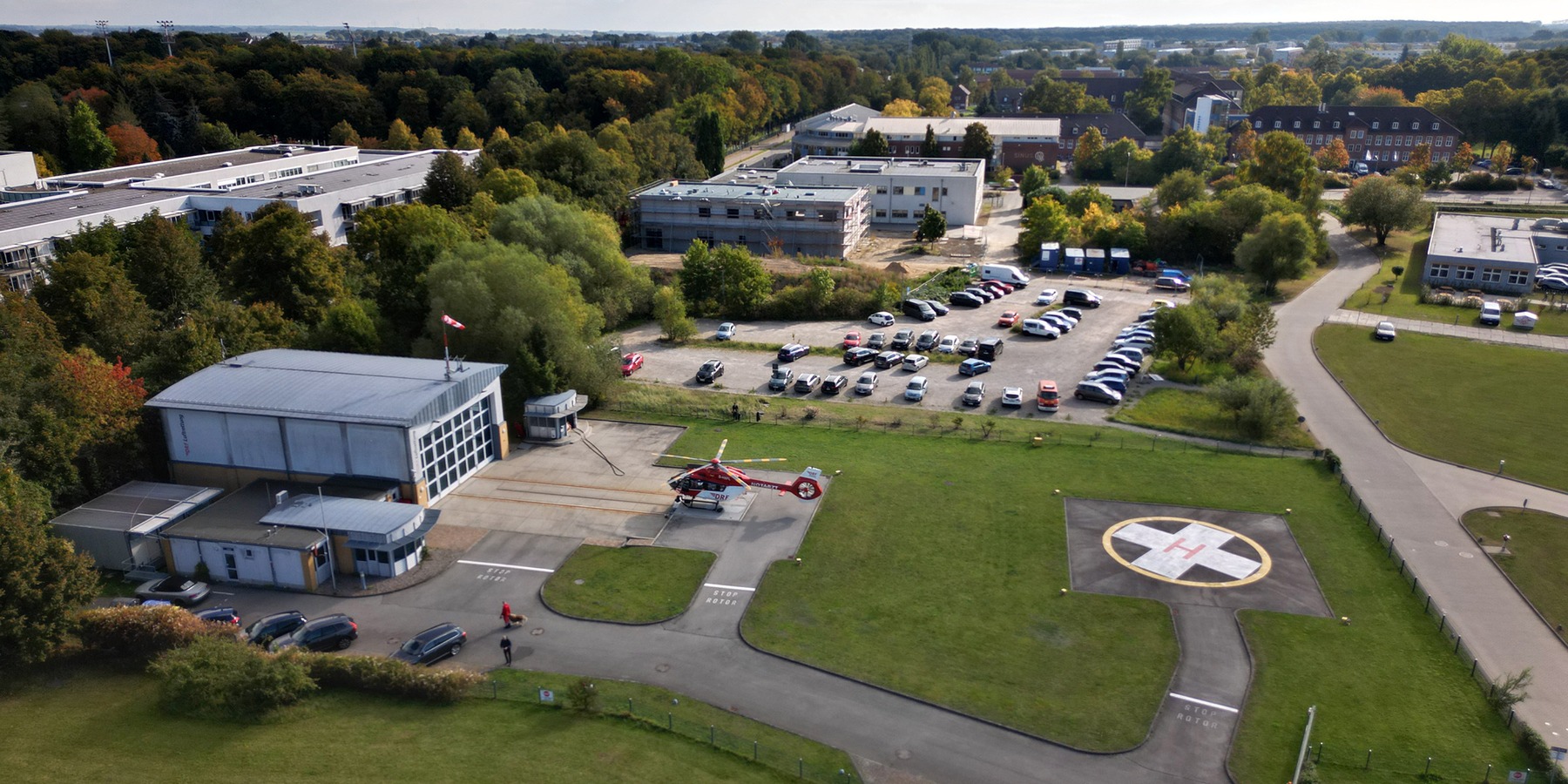 Luftbild vom derzeitigem Standort der DRF Luftrettungsstation Greifswald mit Hangar, Start- und Landeplatz - im Hintergrund der Parkplatz - geplanter Standort für die neue Luftrettung © 2025 Christian Hoffmann (SBL-MV / Ministerium für Finanzen und Digitalisierung Mecklenburg-Vorpommern)