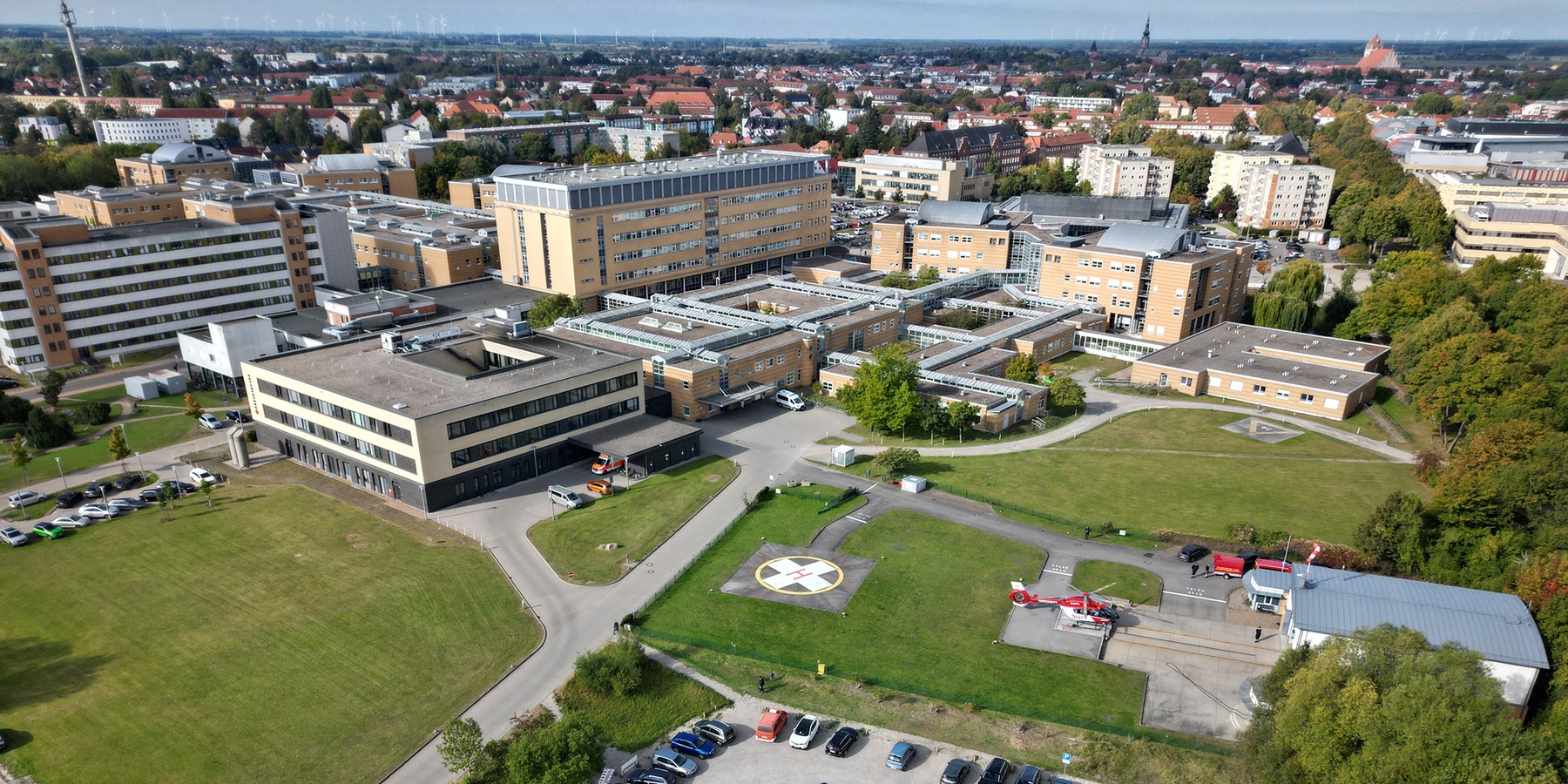 Luftbild mit Blick auf das Klinikum der Universitätsmedizin Greifswald mit dem derzeitigen Standort der DRF Luftrettungsstation (rechts) © 2025 Christian Hoffmann (SBL-MV / Ministerium für Finanzen und Digitalisierung Mecklenburg-Vorpommern)