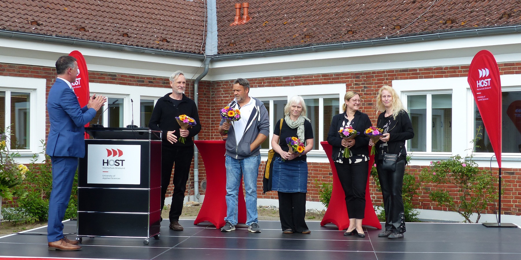 Blumen des Rektors für die Architekten, den Bauleiter und die Projektverantwortlichen des SBL Greifswald, v.l.n.r.: Rektor Prof. Dr. Ralph Sonntag, Architekt Wolfgang Warnkross, Architektin Sandra Hütter und Bauleiter Hagen Becker vom beauftragten Archite © 2026 SBL Greifswald