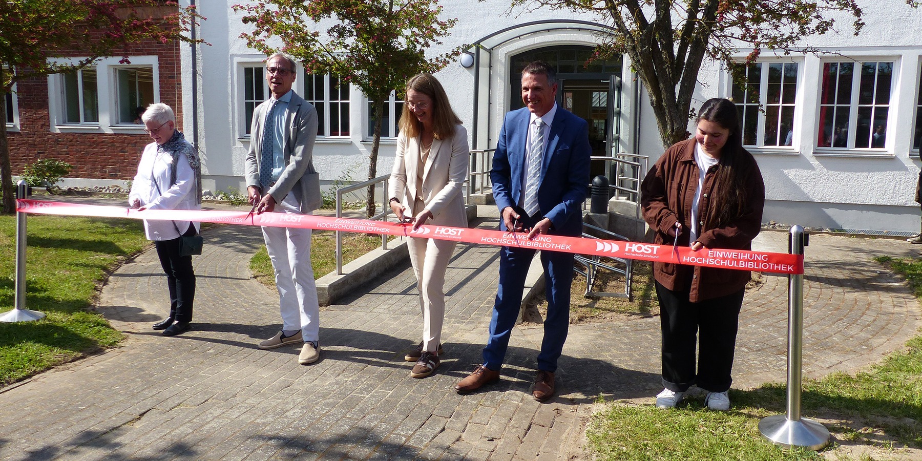 Feierlicher Banddurchschnitt vor dem Haupteingang der Hochschulbibliothek, v.l.n.r.: Bibliotheksleiterin Andrea Glöckner, Amtsleiter SBL Greifswald Stephan Aufdermauer, Ministerin Bettina Martin, Rektor Prof. Dr. Ralph Sonntag und Diana Galieva als Vertre © 2026 SBL Greifswald