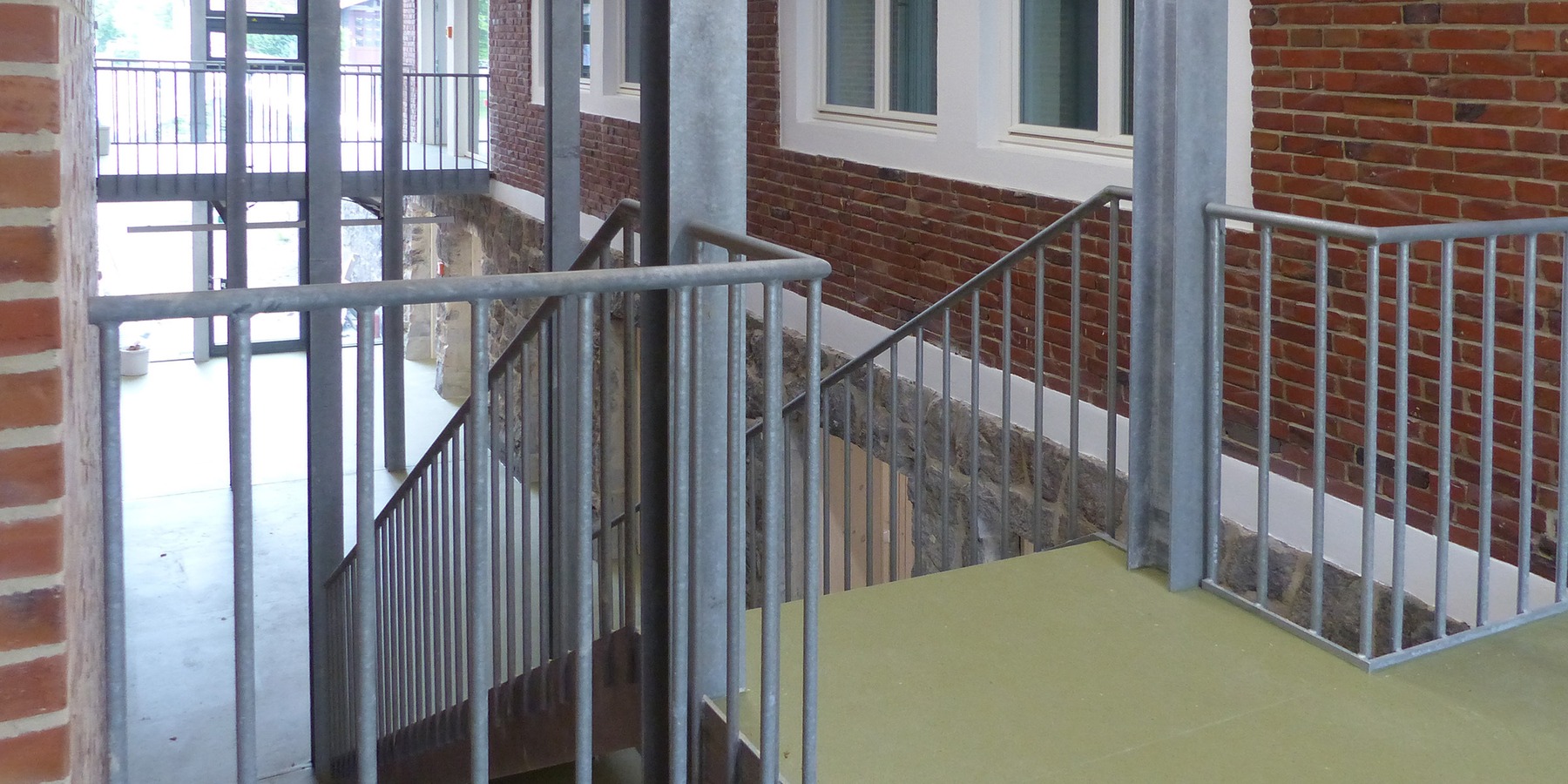 Verbinder innen - Blick vom Erdgeschoss zum Untergeschoss, auf die frühere Außenwand des Bestandsgebäudes © 2026 SBL Greifswald