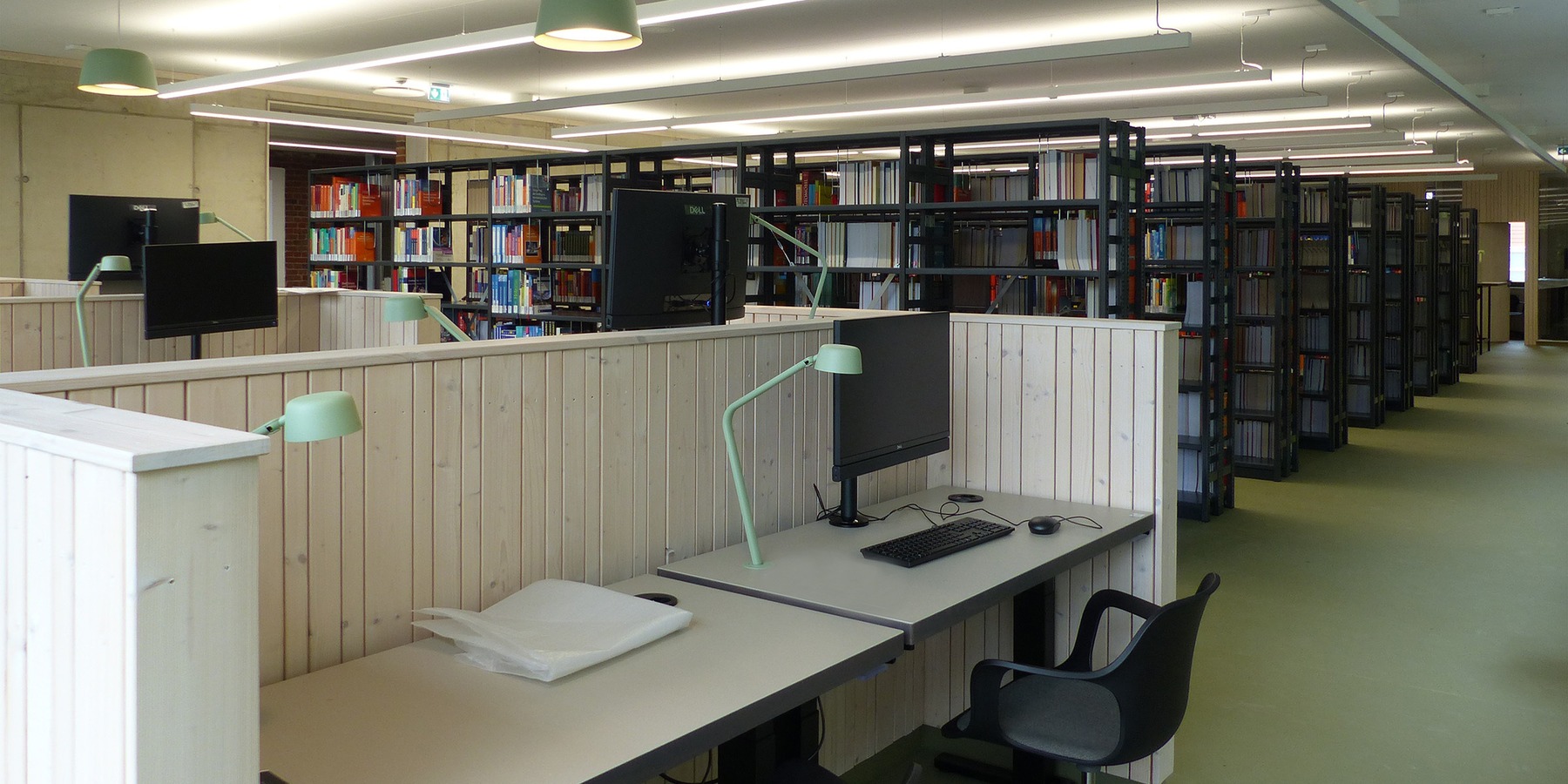 Freihandbereich mit Doppel-Arbeitsplätzen im Untergeschoss des Neubaus © 2026 SBL Greifswald