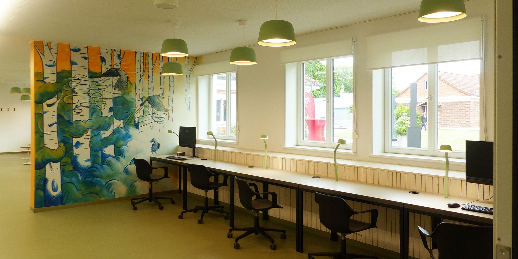 Flurbereich des Bestandsbaus mit farbiger Wandgestaltung und Leseplätzen © 2026 SBL Greifswald