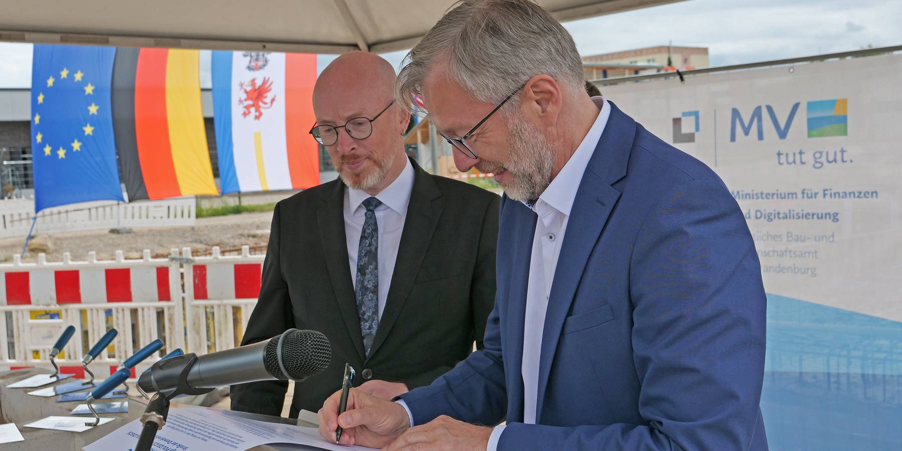 Innenminister Christian Pegel (li.) und Finanzminister Dr. Heiko Geue unterschreiben die Urkunde der  Grundsteinlegung. © 2026 SBL Neubrandenburg