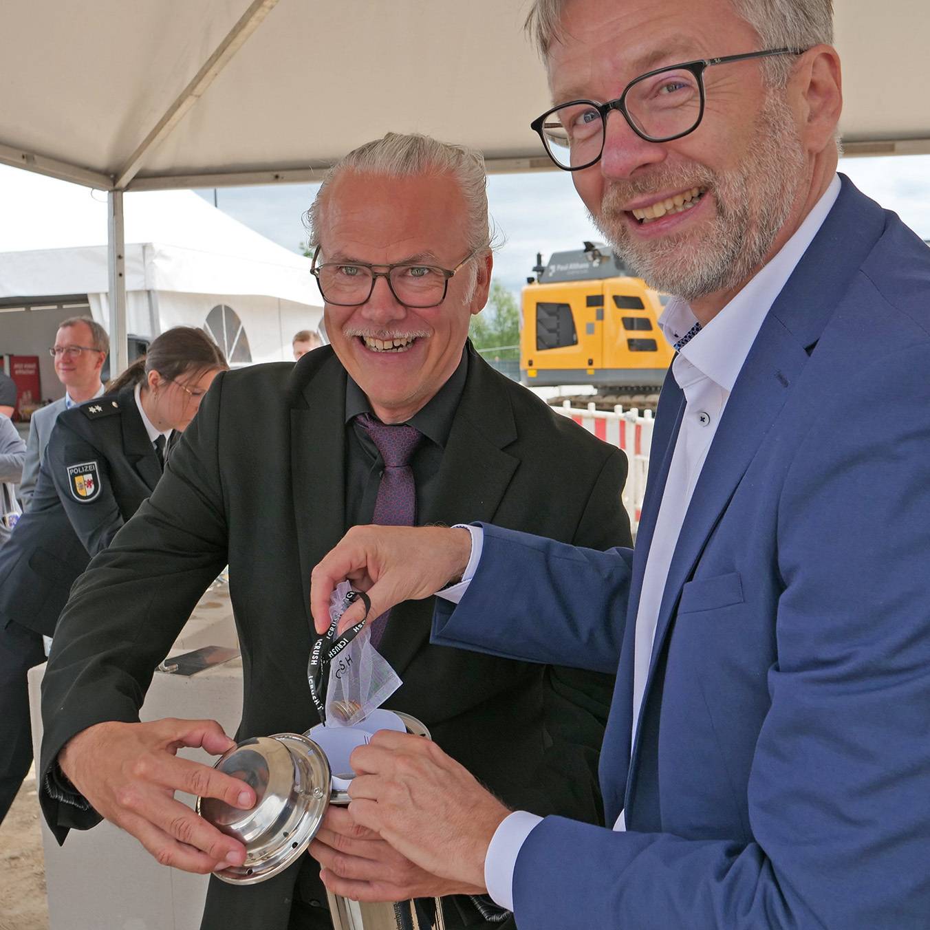 Amtsleiter Jens Rott (li.) und Finanzminister Dr. Heiko Geue füllen den Grundstein. © 2026 SBL Neubrandenburg