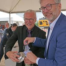 Amtsleiter Jens Rott (li.) und Finanzminister Dr. Heiko Geue füllen den Grundstein. © 2026 SBL Neubrandenburg