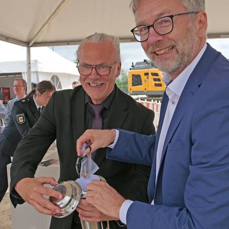 Amtsleiter Jens Rott (li.) und Finanzminister Dr. Heiko Geue füllen den Grundstein. © 2026 SBL Neubrandenburg