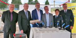 Befüllte  Zeitkapsel  präsentieren (von links) Baudirektor Jens Rott, Minister für Inneres und Bau Christian Pegel, Minister für Finanzen und Digitalisierung Dr. Heiko Geue, Landtagsabgeordneter Dirk Stamer, Polizeipräsidentin von Rostock Anja Hamann und  © 2026 SBL Neubrandenburg