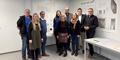 Das Preisgericht vor dem Siegerentwurf (von links: Holger Stark, Catleen Hofbauer, Thomas Möller, Carmen-Alina Botezatu, Petra Steeger, Bernd Kommnick, Claudia Lochmann, Prof. Dr. Carsten Kremer und Christoph Meyn). © 2026 SBL Rostock