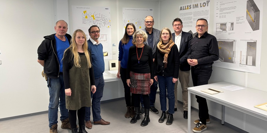 Das Preisgericht vor dem Siegerentwurf (von links: Holger Stark, Catleen Hofbauer, Thomas Möller, Carmen-Alina Botezatu, Petra Steeger, Bernd Kommnick, Claudia Lochmann, Prof. Dr. Carsten Kremer und Christoph Meyn). © 2026 SBL Rostock