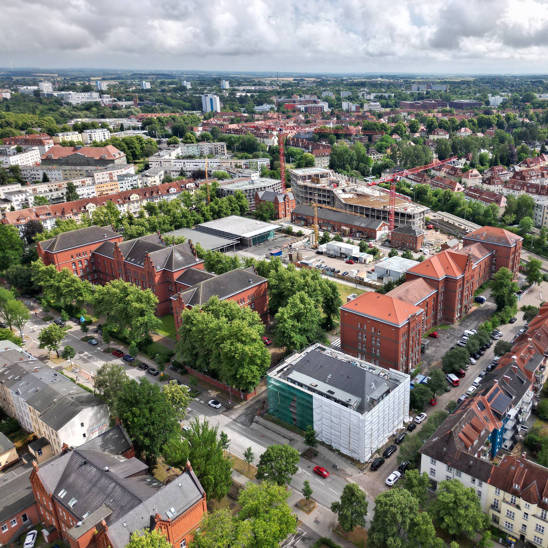 Blick auf den Campus Ulmenstraße Ende Juni 2026 - im Vordergrund, weiß eingehüllt, das Haus 2. © 2026 Christian Hoffmann (SBL-MV / Ministerium für Finanzen und Digitalisierung MV)