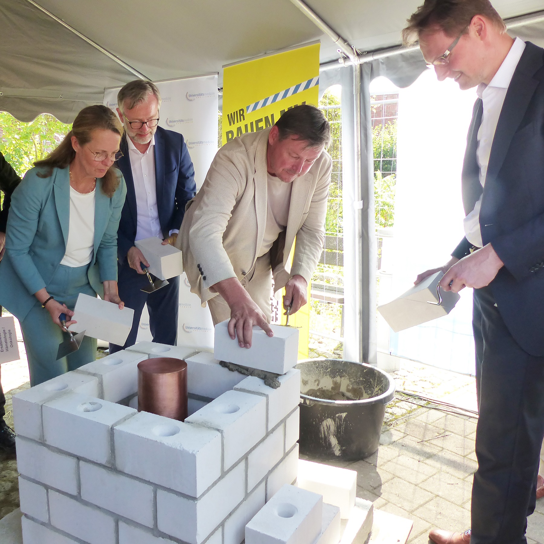 Die letzte Steinschicht wird gemauert, v.l.n.r.: Wissenschaftsministerin Bettina Martin, Finanzminister Dr. Heiko Geue, Landtagsmitglied Marcel Falk und Klinikleiter Prof. Dr. Dr. Adrian Schwarzer © 2026 SBL Greifswald