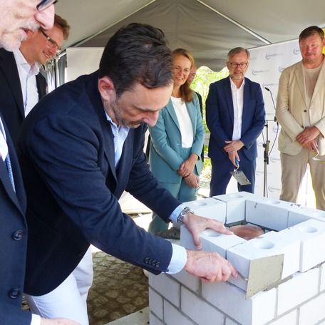 Die letzte Steinschicht wird gemauert, v.l.n.r.: Klinikleiter Prof. Dr. Dr. Adrian Schwarzer (im Hintergrund), Stellv. Ärztlicher Vorstand Prof. Dr. med. Stephan Kersting, Wissenschaftsministerin Bettina Martin, Finanzminister Dr. Heiko Geue, Landtagsmitg © 2026 SBL Greifswald
