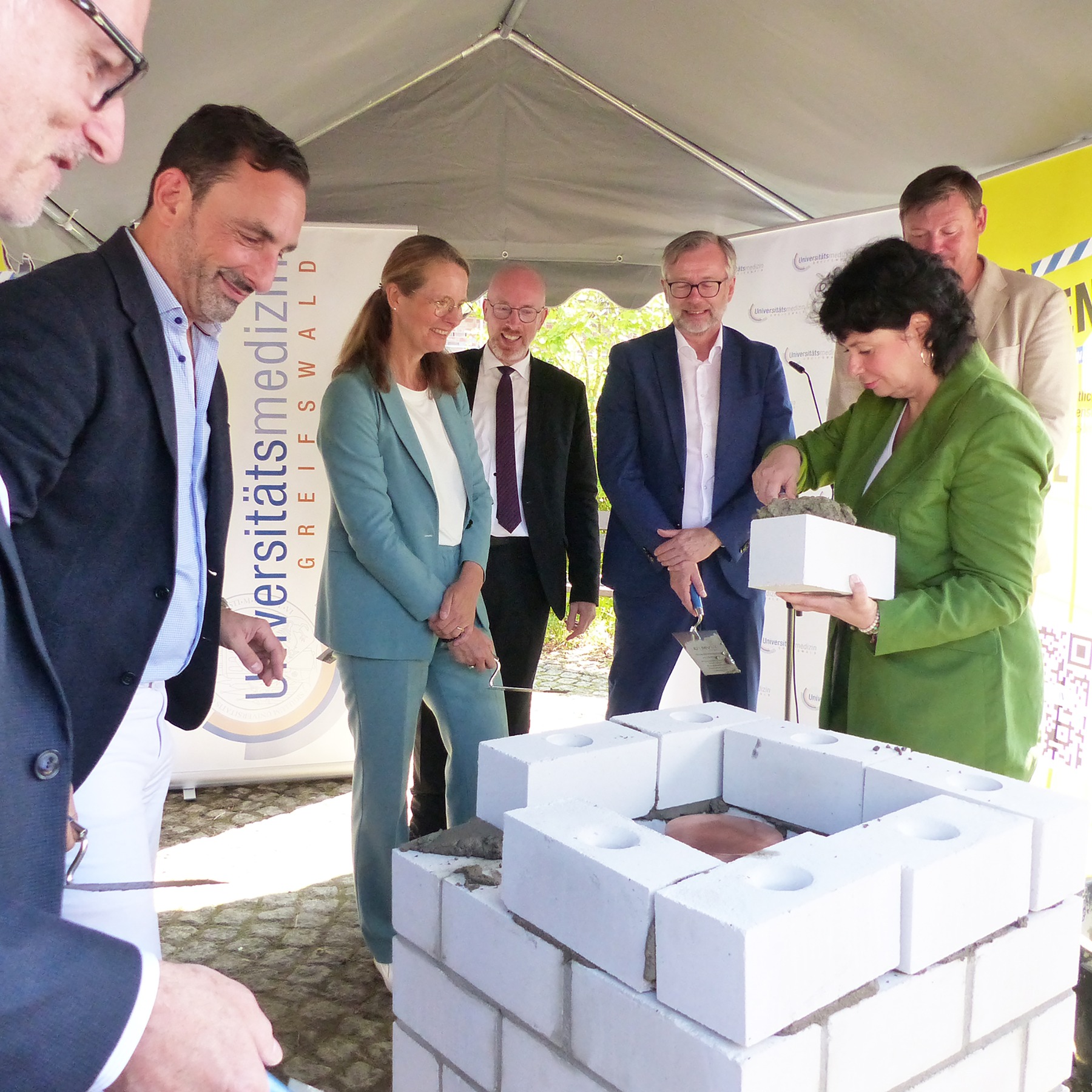 Die letzte Schicht wird gemauert - Jana Luntz, Pflegevorständin der UMG, setzt den letzten Stein © 2026 SBL Greifswald
