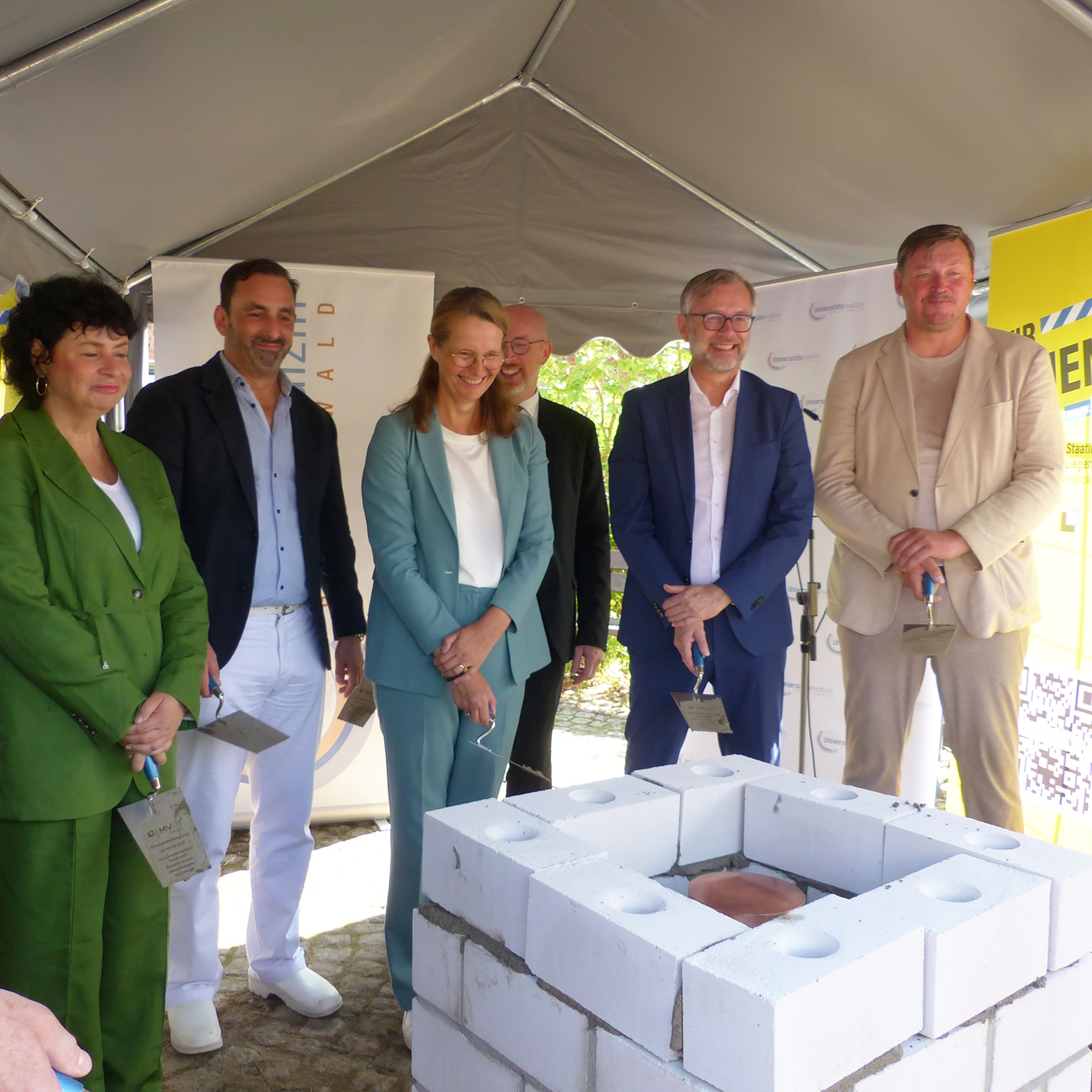 Der Grundstein ist gesetzt, die Kartusche versenkt - zufriedene und glückliche Gesichter über den erreichten wichtigen Meilenstein © 2026 SBL Greifswald