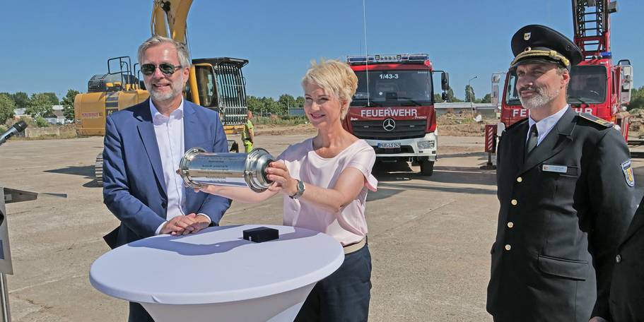 Geschafft! Ministerpräsidentin des Landes Mecklenburg-Vorpommern Manuela Schwesig mit der Zeitkapsel und Minister für Finanzen und Digitalisierung Dr. Heiko Geue (li.) und Schulleiter Branddirektor Johannes Schuldt (re.). © 2026 SBL Neubrandenburg